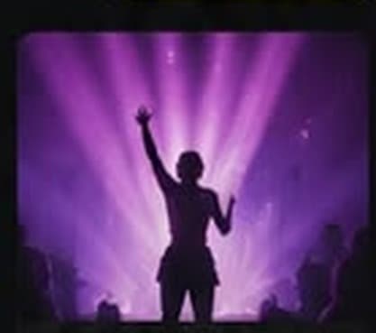 Üniversite festivalinde mor sahne ışıkları altında kalabalık